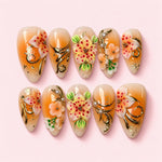 Apricot Lily almond press-on nails in cream and apricot with sculpted speckled lilies, gold vines and pearls