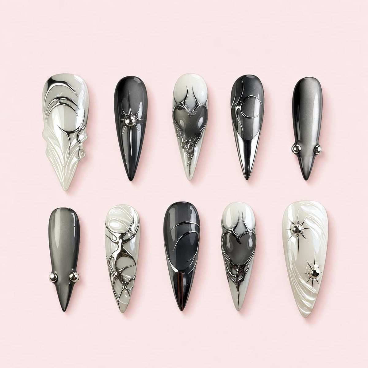 Ashen Heart stiletto press-on nails in black, grey and bone with sculpted hearts, silver stars and beads