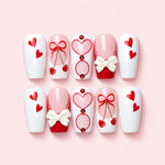 Cherry Bow short coffin press-on nails in white and red with painted bows, cherries, hearts and a sculpted white bow
