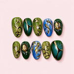 Emerald Vine almond press-on nails in moss and forest green with gold-toned vine work and champagne cut stones