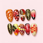 Golden Tropics almond press-on nails with sculpted coral flowers, carved gold baroque nails and citrus segments