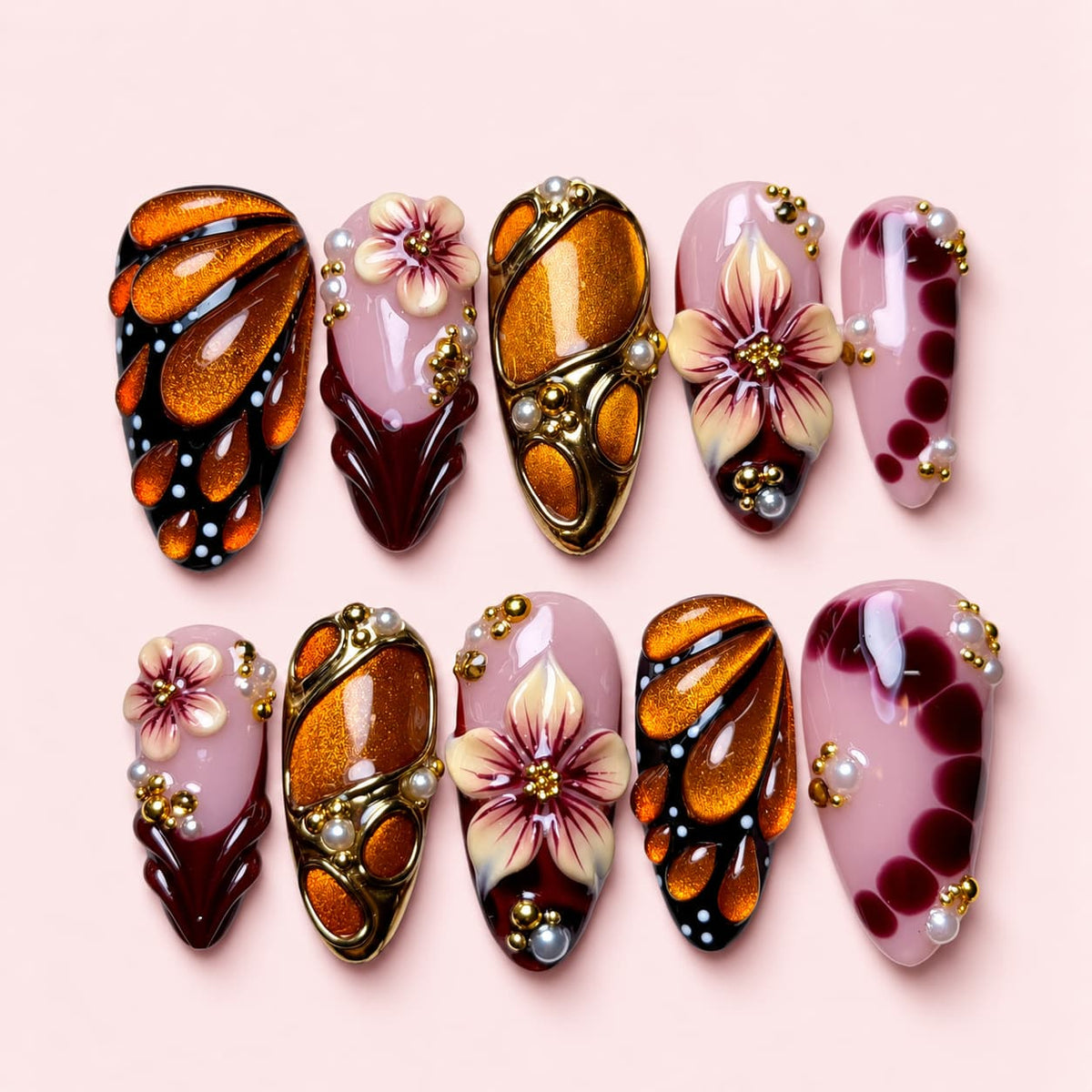 Monarch Bloom almond press-on nails with amber butterfly wings, sculpted cream and plum flowers and gold-toned frames