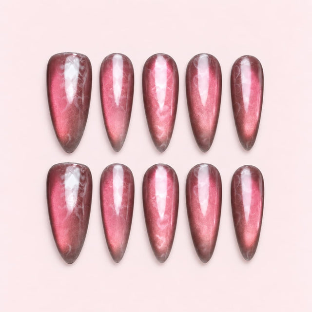 Pink cat-eye heart stiletto press-on nails with rosy-pink shimmer, plum edges, subtle heart details and a glossy velvet-like finish.