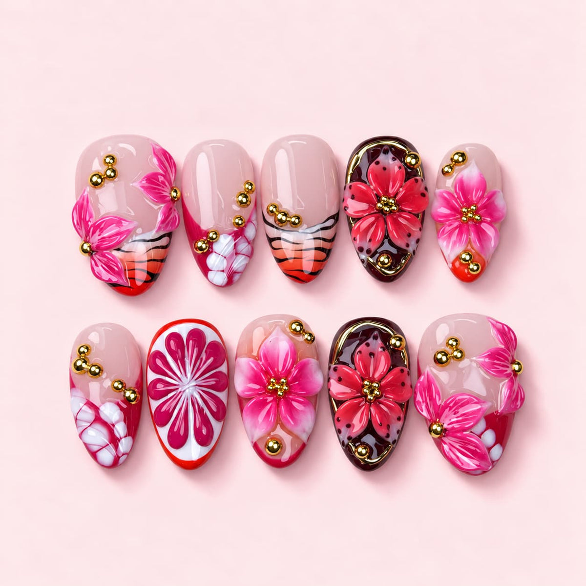 Pink Pomelo short almond press-on nails with sculpted magenta lilies, a carved pomelo slice and oxblood accent nails