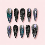 Rose Relic Stiletto press-on nails in dusty rose with raised silver cell work, a sculpted bow and spiral nail