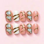Rose Signet short square press-on nails in peach nude and cream with gold-framed holographic panels and gold bands