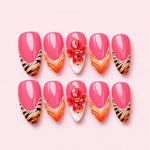 Tiger Lily almond press-on nails in watermelon pink with tiger stripe tips and a sculpted red speckled lily