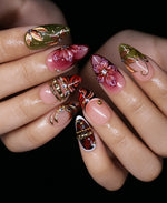Fall floral short almond press-on nails worn on hands with burgundy flowers, olive leaf art, gold frames, and animal print accents