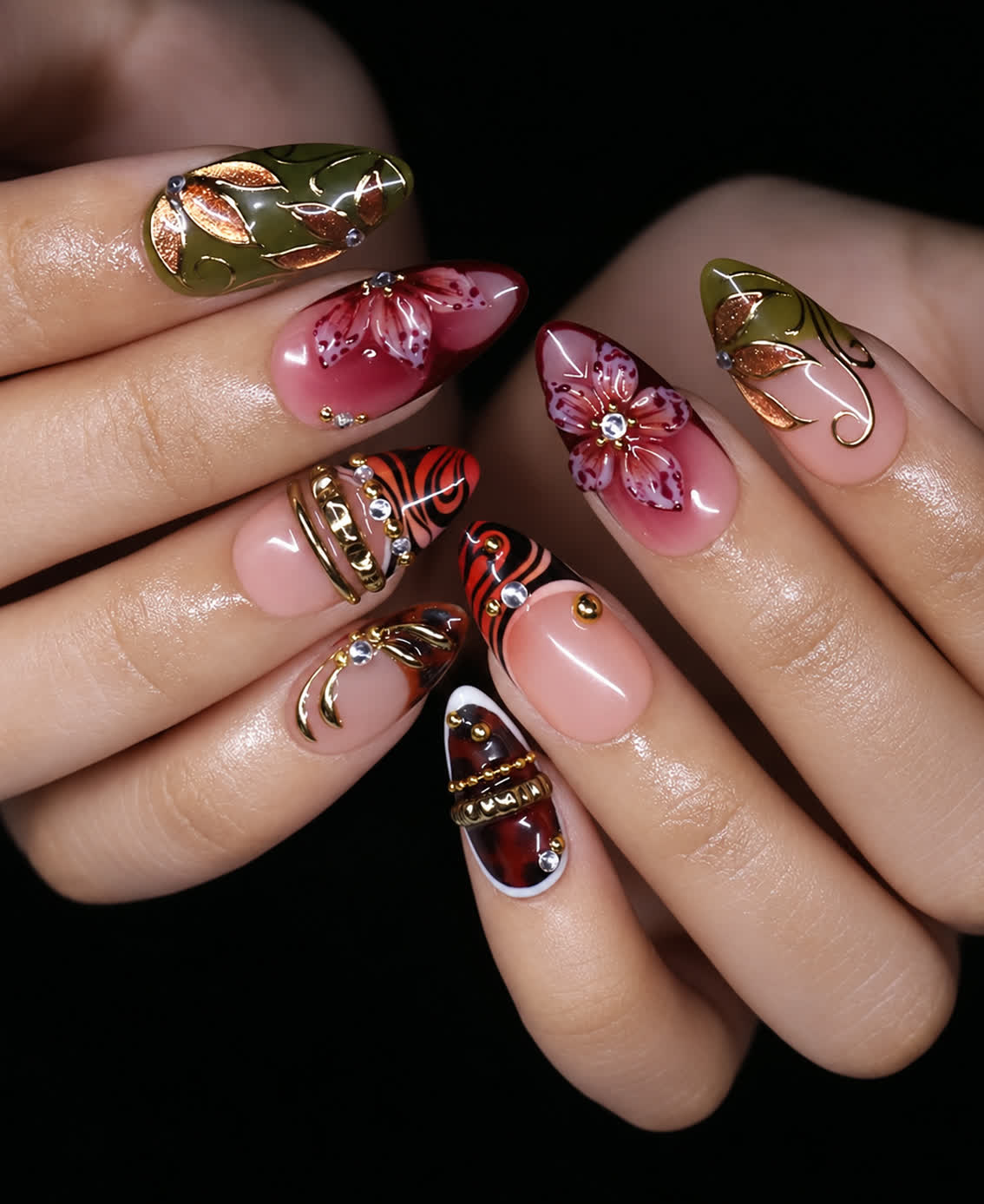 Fall floral short almond press-on nails worn on hands with burgundy flowers, olive leaf art, gold frames, and animal print accents
