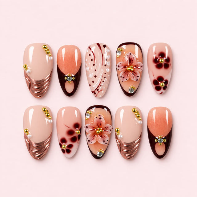 Brown floral French tip short nails with nude base, 3D flowers, pearls, and gold accents displayed as a press-on nail set.