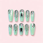 Mint Aura Spiderweb Coffin Press-On Nails with an iridescent mint base, black spiderwebs, spider motifs, and silver gemstone accents.