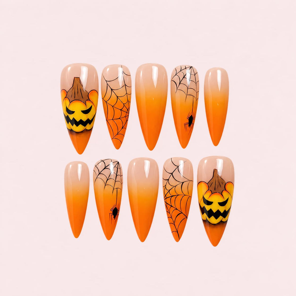 Orange Pumpkin Halloween Stiletto Press-On Nails with nude-to-orange ombré, jack-o'-lantern accents, black spider webs, and spider details.