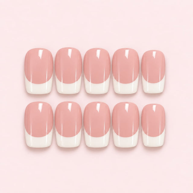 Set of 10 pink French tip short square press-on nails with a soft mauve base and classic white tips in a clear case.