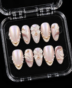 Pink pearl chrome press-on nails with iridescent milky pink finish, pearl accents, 3D bows, and white sculpted details.
