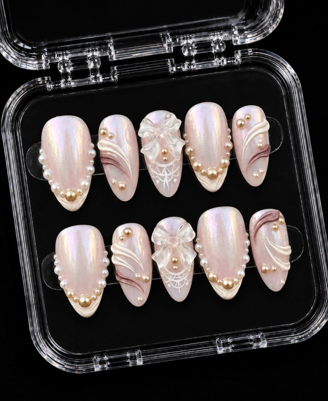 Pink pearl chrome press-on nails with iridescent milky pink finish, pearl accents, 3D bows, and white sculpted details.