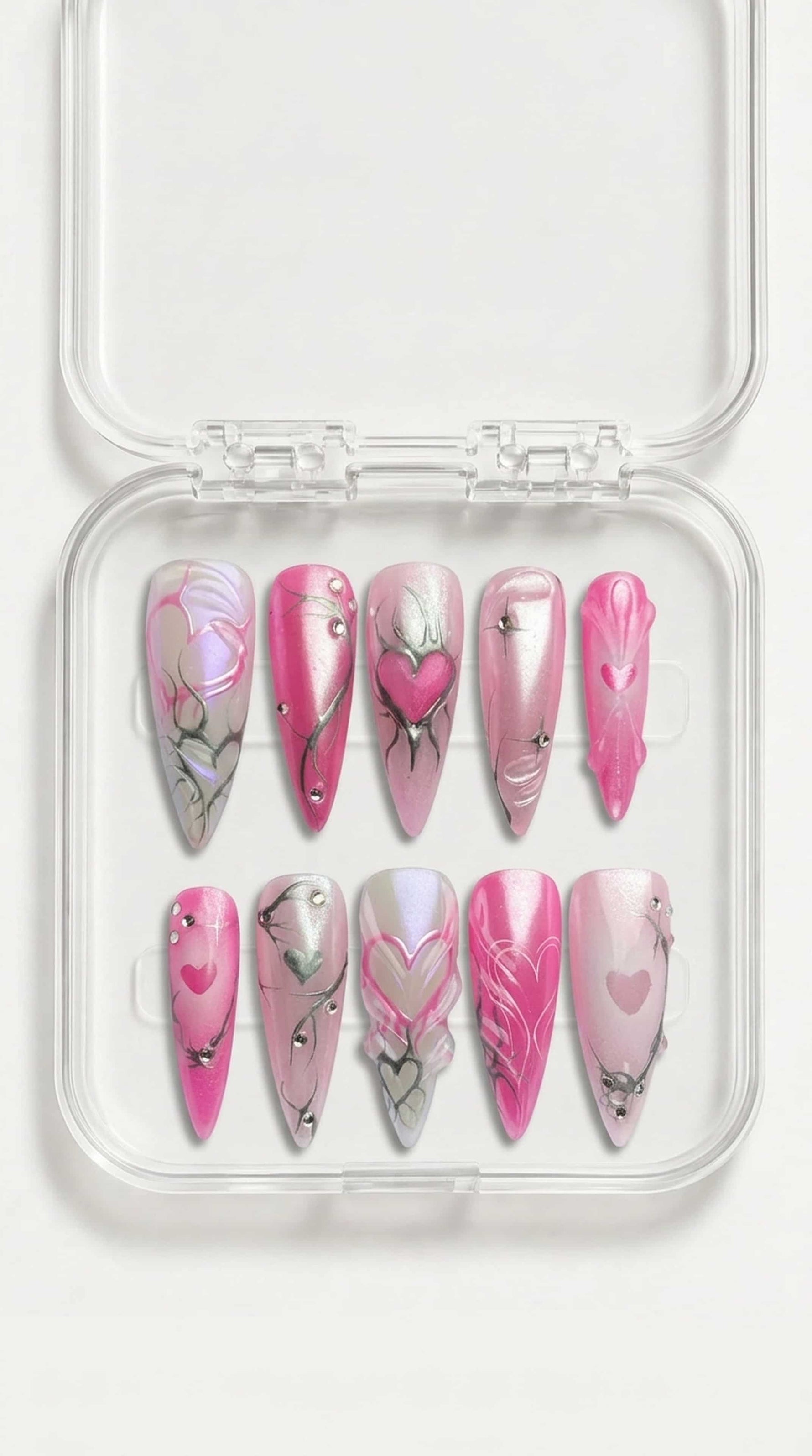 Pink pearl stiletto press-on nails with hand-painted hearts, silver swirl details and gemstone accents