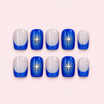 Royal blue French tip short square press-on nails with a nude sheer base, silver line detailing, star and gemstone accents