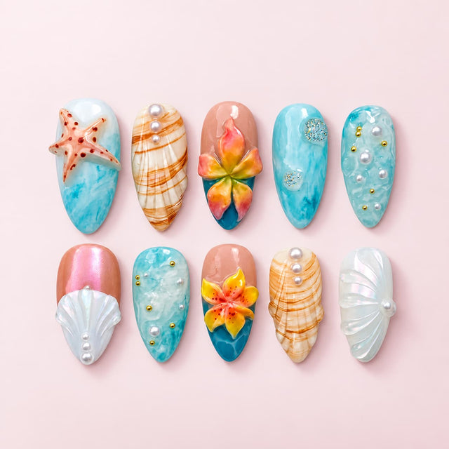 Tropical starfish stiletto nails with ocean marble bases, 3D flowers, seashells, pearls, gold beads, and shimmer details